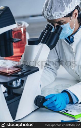 Scientist Analyzing Cultured Artificial Meat Sample under the Microscope in Laboratory