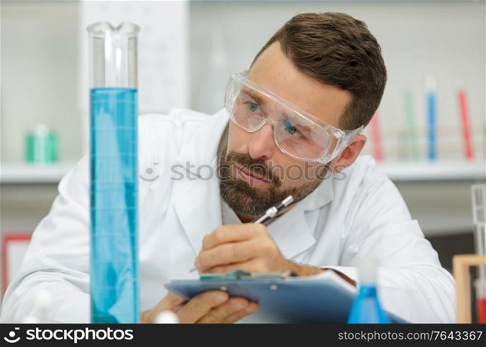 scientist checking a solution in conical flask