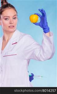 Scientist doctor with apple and syringe. GM Food.. Scientist doctor with apple hiding syringe. Woman chemist holding genetically modified fruit. GM food modification.