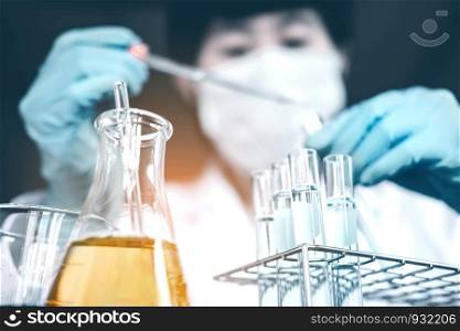 Scientist dropping chemical liquid to flask in lab Glass laboratory chemical test,Laboratory research concept