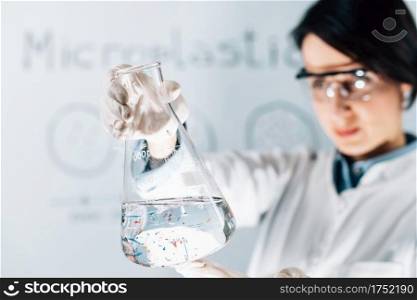Scientist examining microplastic particles in a water s&le. Microplastic Particles in a Water S&le