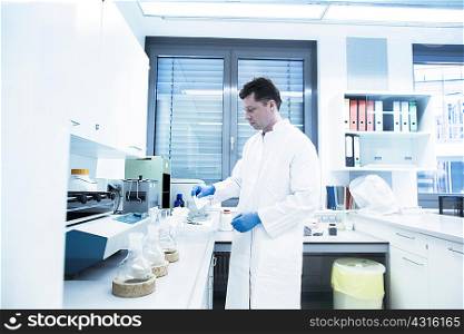 Scientist examining sample inside beaker in laboratory