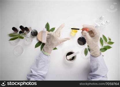 Scientist hand holding green leaf in glass cuvette on laboratory. biotechnology concept.