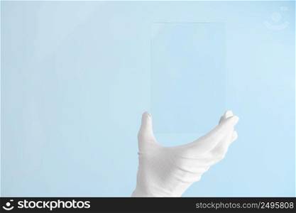 Scientist hand in glove show rectangle piece of new research prototype of transparent clear glass or plastic material