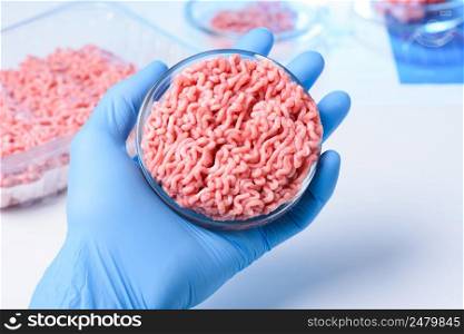 Scientist hand in protective glove hold petri dish with raw ground meat sample