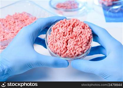 Scientist hands in protective gloves hold petri dish with raw ground meat sample