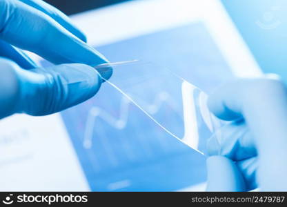 Scientist hold and bend in fingers small piece of transparent material, new type of material with different properties research concept