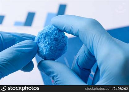 Scientist hold big blue chemical crystal in laboratory