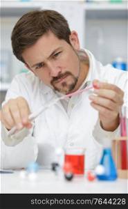 scientist holding a tube and pipette