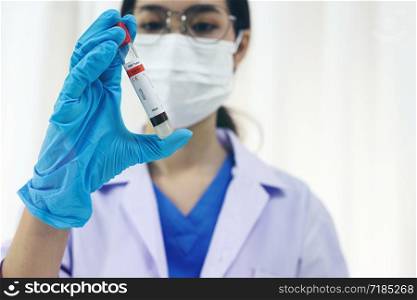 Scientist holding Coronavirus covid-19 infected blood sample tube. DNA testing of the blood in the laboratory with blood sample collection tubes and syringe Coronavirus Covid-19 vaccine research
