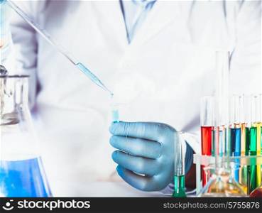 Scientist holds eppendorf tube and pipette. Focus on test tube