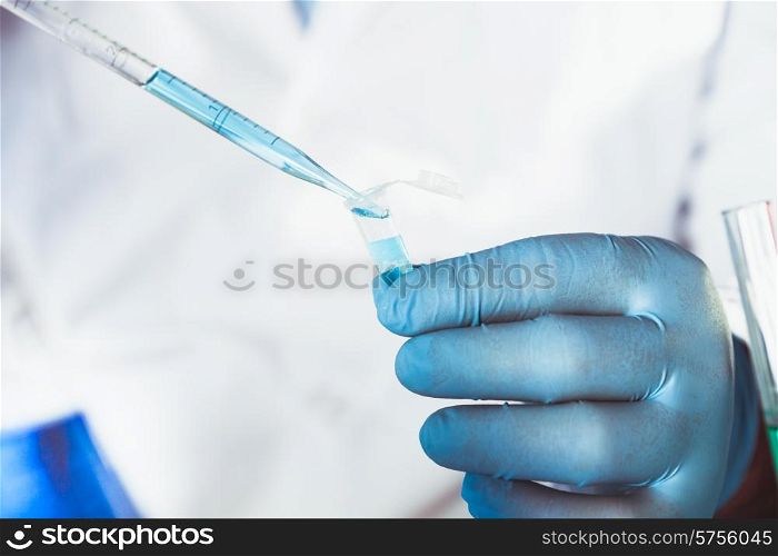 Scientist holds eppendorf tube and pipette. Focus on test tube