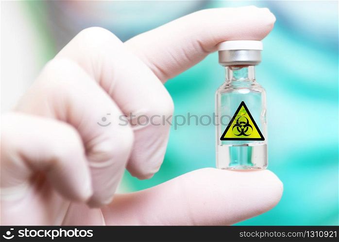 Scientist in protective mask holding sample tube with biohazard sign .. Scientist in protective mask holding sample tube with biohazard sign.
