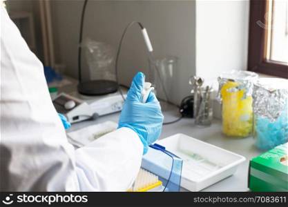 Scientist in the lab using pipette to fill test tubes