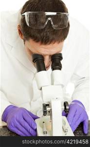 Scientist looking at a sample through a microscope.