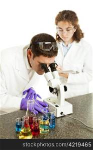 Scientist looking through microscope while his assistant takes notes. Isolated on white.