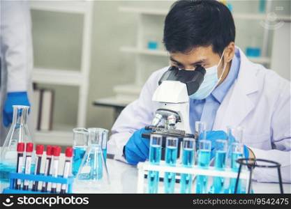 Scientist man look into Microscope research in science laboratory. Asian scientist looking equipment laboratory chemistry labs. Covid-19 coronavirus biochemistry research experiment vaccine concept