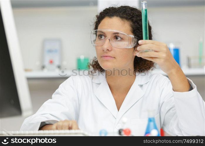 scientist pipetting solution into the glass test tube