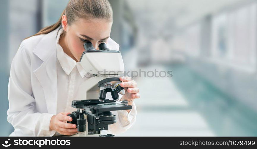 Scientist researcher using microscope in laboratory. Medical healthcare technology and pharmaceutical research and development concept.