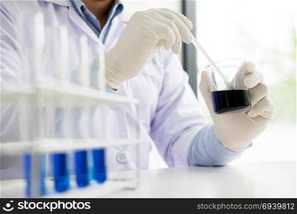 scientist stirs reagents beaker in Science Laboratory
