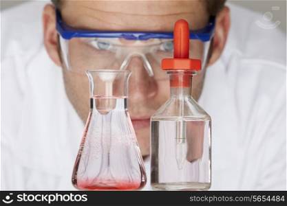 Scientist Studying Flask And Bottle With Dropper