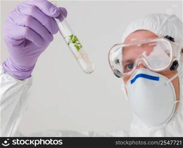Scientist with a sapling in a test tube