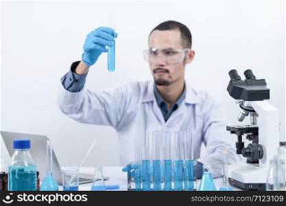 scientist with equipment and science experiments, laboratory glassware containing chemical liquid for research or analyzing a sample into test tube in laboratory.