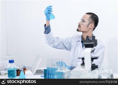scientist with equipment and science experiments, laboratory glassware containing chemical liquid for research or analyzing a sample into test tube in laboratory.