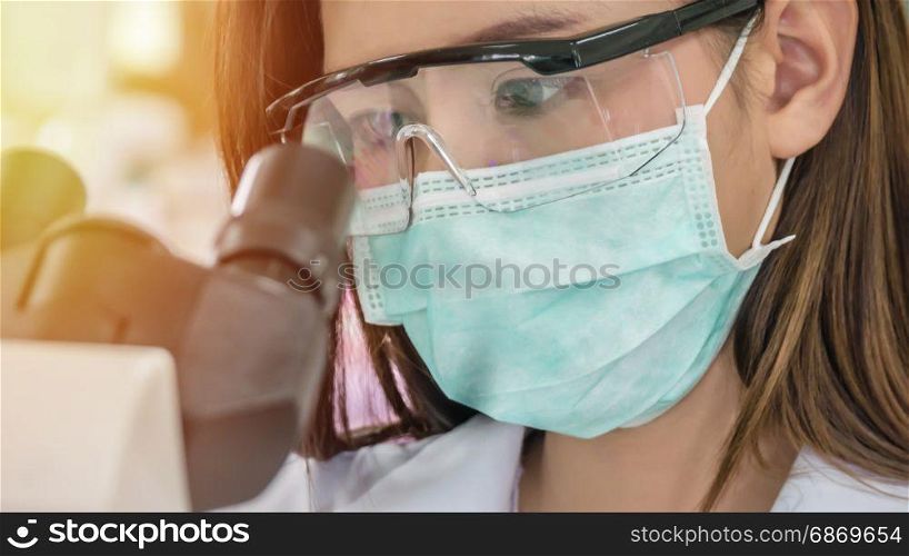Scientist working at laboratory. scientist looking through a microscope in a laboratory
