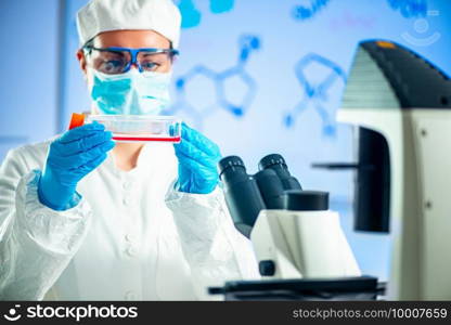  Scientist working in a laboratory, placing microscope slide on the stage
