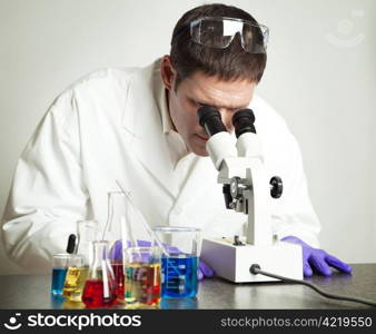 Scientist working with chemicals and a microscope in his laboratory.