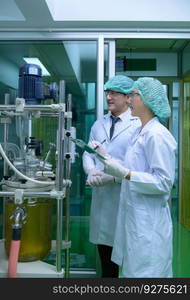 Scientists and assistants are in the machine room extracting oil and cannabis seeds. Inspecting cannabis oil extractor before starting to extract the prepared cannabis