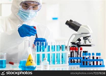 Scientists hold blood sample test tube and examine for his research and develop vaccine for coronavirus covid-19 pandemic. Medical Science and technology concept.