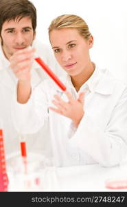 Scientists in laboratory - flu virus test tube with red liquid