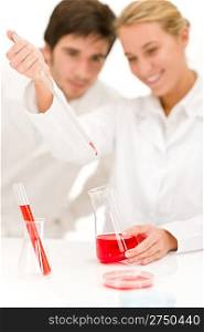 Scientists in laboratory - flu virus test tube with red liquid