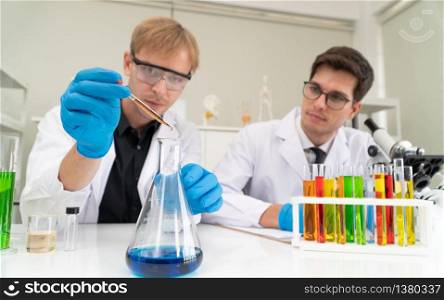 Scientists or doctors are researching to find new Medicine and prevent, destroy new strains of the virus (Coronavirus) through tube and beaker in a chemistry lab. Concept of laboratory and scientist