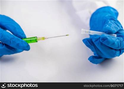 Scientists wearing masks and gloves Holding a syringe with a vaccine to prevent covic-19