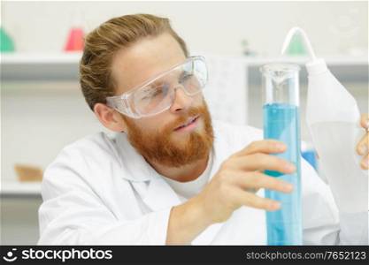 scientists working with large vat in the lab