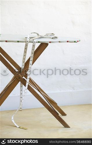 Scissors and measuring tape on ironing board