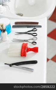 Scissors combs razor and brush on counter in barber shop