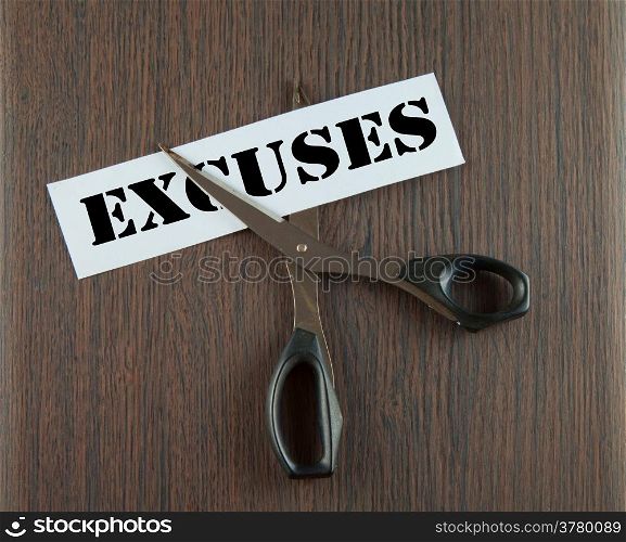"Scissors cutting the word "Crisis" written on a paper strip, over wooden background"