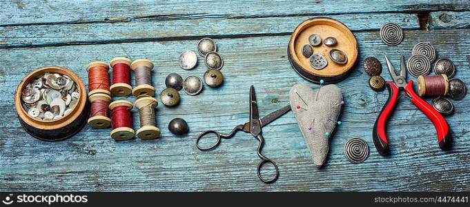 Scissors ,iron, stylish old-fashioned buttons and thread on wooden background