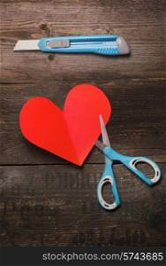 scissors,knife and heart of the paper on a dark wooden background.Valentine&#39;s day