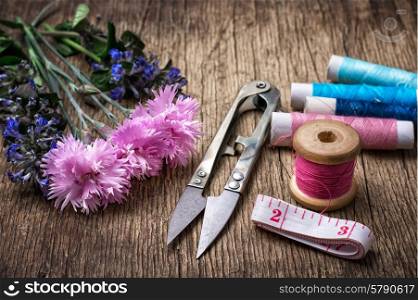 Scissors ,thread and buttons on unhewn darianna background in vintage style