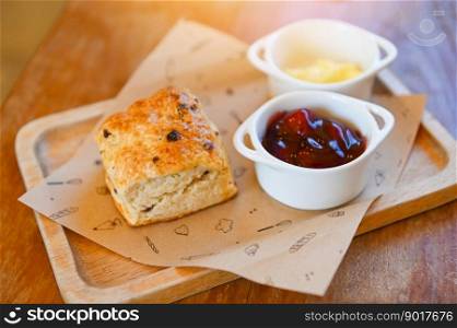 scones and jam on wooden plate, served scones and cream for dessert and tea - fresh homemade butter scones