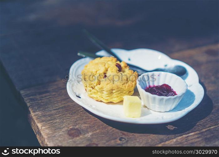 scones with clotted cream and jam, strawberries on the background, selective focus