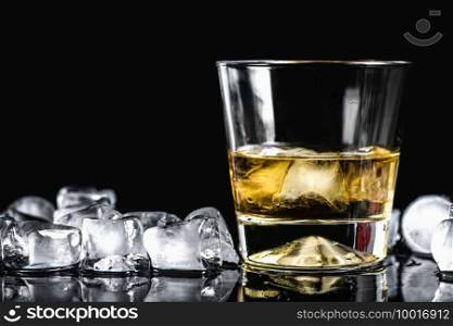 Scotch in a glass with ice cubes, black reflective background. Scotch in a Glass with Ice Cubes, Black Background