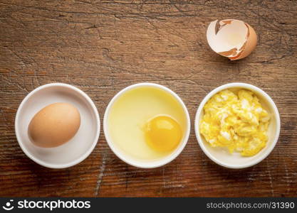 scrambled egg abstract - white bowls with eggs against rustic, weathered wood