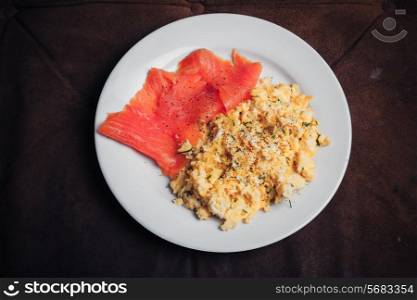 Scrambled eggs and salmon on a white plate