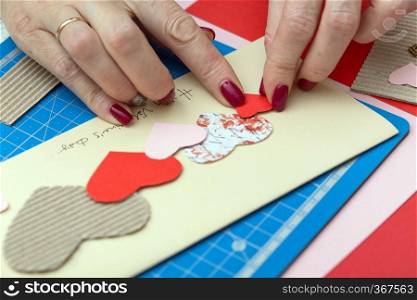 scrapbook background. girl making a postcard on the valentine’s day 